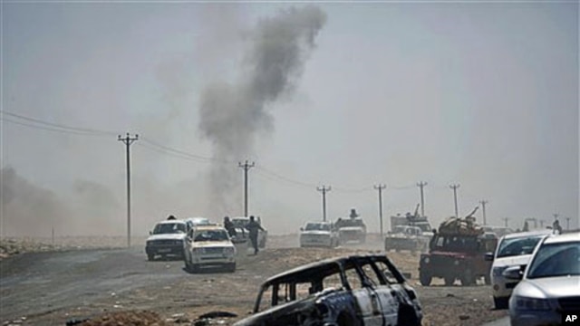 Libyan rebels retreat followed by incoming shells fired by pro-Gadhafi forces along the front line near Brega, Libya, April 5, 2011