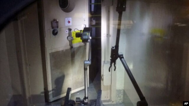 A remote-controlled robot called "Packbot", which has capabilities including maneuvering through buildings, taking images, and measuring radiation levels, opens a door at Tokyo Electric Power (TEPCO) Co.'s crippled Fukushima Daiichi Nuclear Power Plant No