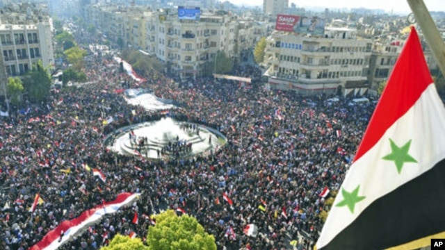 In this handout photograph released by Syria's national news agency SANA, supporters of Syria's President Bashar al-Assad attend a rally at al-Sabaa Bahrat square in Damascus, Syria, November 28, 2011.