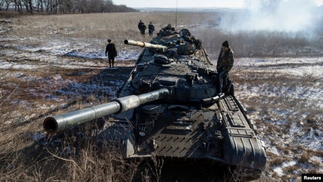 Phiến quân ly khai của quân đội tự xưng Cộng hòa Nhân dân Donetsk đứng trên nóc xe tăng tại một chốt kiểm soát trên đường từ thị trấn Vuhlehirsk đến Debaltseve, 18/2/2015.