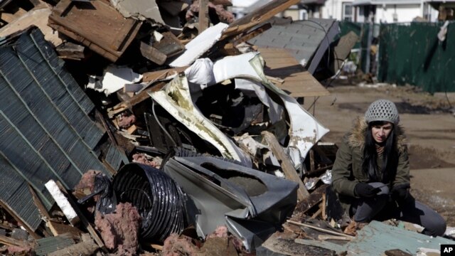 Julie Traina tries to recover some personal items from the destroyed home of her parents in the Staten Island borough of New York, November 2, 2012. 