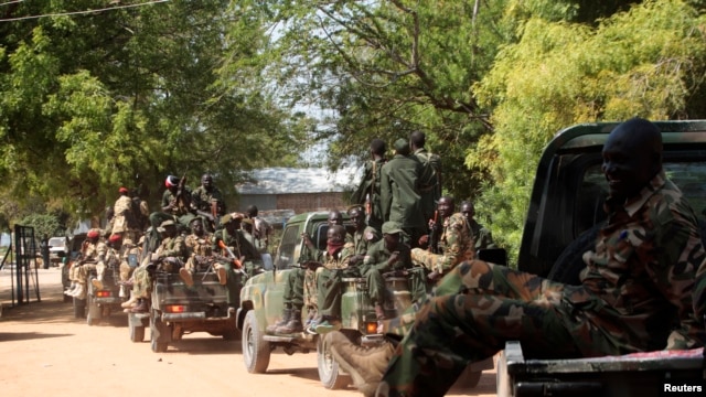 South Sudan army soldiers hold their weapons as they ride on a truck in Bor, Dec. 25, 2013. 