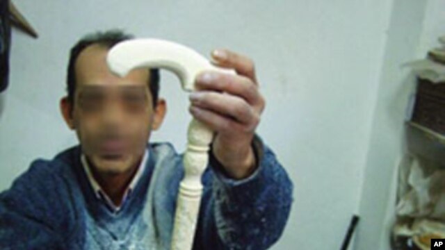 A carver displays an ivory walking stick, an item popular with Egyptian and Gulf Arab buyers