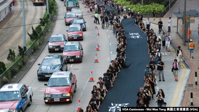 Những người phản đối cầm dải vải đen dài 500 mét tuần hành trên đường phố Hong Kong hôm Chủ nhật, để chứng tỏ họ quyết tâm muốn có phổ thông đầu phiếu thực sự, 14/9/2014.
