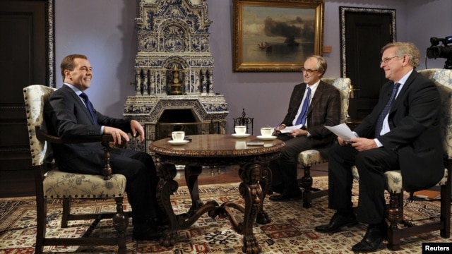 Russian Prime Minister Dmitry Medvedev (L) gives an interview to journalists representing French media ahead of his visit to Paris at the Gorki state residence outside Moscow, November 26, 2012.
