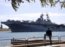 An Egyptian watches US amphibious assault ships USS Kearsarge as it sails at the Suez canal in Ismailia , Egypt, March 2, 2011