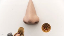 A visitor look over the sculpture "Vortex Eau De Parfum" by Jim Lampie at the Frieze Art Fair in New York