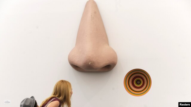 A visitor look over the sculpture "Vortex Eau De Parfum" by Jim Lampie at the Frieze Art Fair in New York