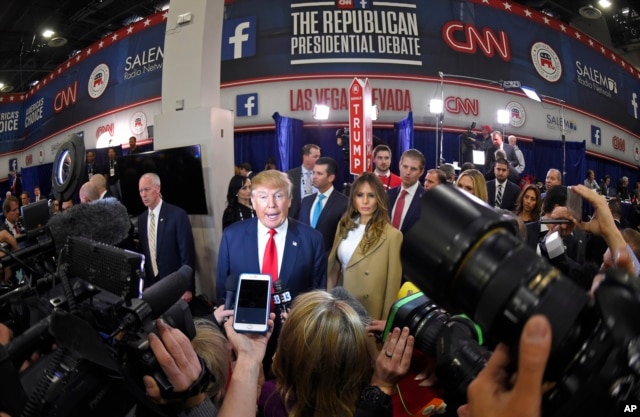 FILE - Donald Trump is joined by his wife, Melania, in the spin room following the CNN Republican presidential debate in Las Vegas, Dec. 15, 2015.