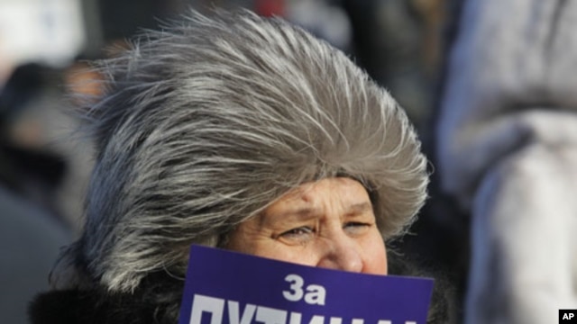 A demonstrator holds a poster reading: "For Putin!" during a rally in support of Putin's candidacy to the presidency in the March 4th election, in St.Petersburg, Russia, Saturday, Feb. 18, 2012.