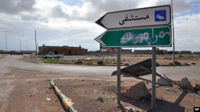 A road sign pointing to the town of Tawergha, a former bastion of support for Moammar Gadhafi, has been painted over with "Misrata," in Arabic, as part of score-settling following Libya's eight-month civil war. 