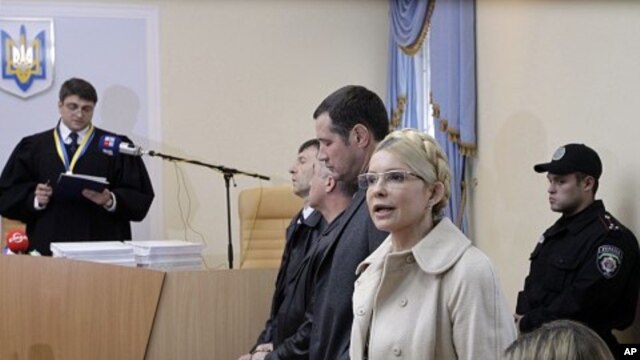 Former Ukrainian Prime Minister Yulia Tymoshenko speaks during her trial, with Judge, Rodion Kireyev, left, reading the indictment at the Pecherskiy District Court in Kiev, Ukraine, October 11, 2011.
