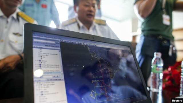Các nhân viên sắp thực hiện việc tìm kiếm chiếc máy bay bị mất tích xem đường bay của máy bay MH370 trên màn hình