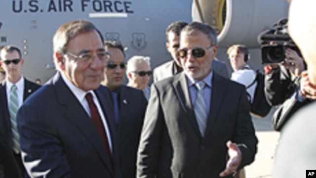 U.S. Secretary of Defense Leon Panetta greets members of the Libyan delegation on the tarmac during his arrival in Tripol, Saturday, Dec., 17, 2011.