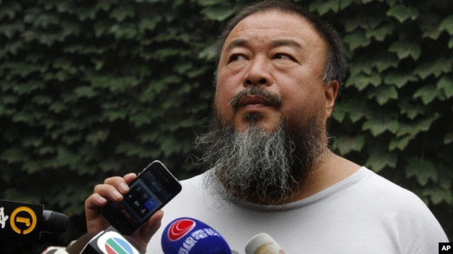 Chinese dissident artist Ai Weiwei listens as his lawyer announces over speakerphone the verdict of Ai's lawsuit against the tax authorities in Beijing, July 20, 2012.