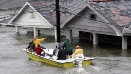 St. Berard Parish deputy sheriff Jerry Reyes uses his boat to rescue residents after Hurricane Katrina hit the area causing flooding in their New Orleans neighborhood, Monday Morning, Aug. 29, 2005.