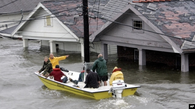 St. Berard Parish deputy sheriff Jerry Reyes uses his boat to rescue residents after Hurricane Katrina hit the area causing flooding in their New Orleans neighborhood, Monday Morning, Aug. 29, 2005.