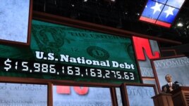 Republican National Committee Chairman Reince Priebus unveils a large U.S. national debt clock at the opening of the 2012 Republican National Convention in Tampa, Florida, August 27, 2012.