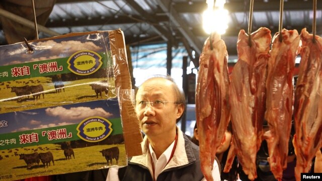 An official from the Taipei City Department of Health inspects a beef stall in a traditional market with reporters in Taipei, March 22, 2012. 