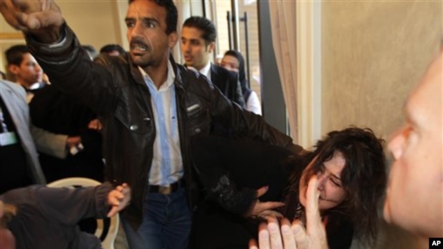 A Ministry of Information official, left, yells at the press to stop filming as he  grabs Iman Al-Obeidi, who said she spent two days in detention after being arrested at a checkpoint in Tripoli, Libya,  and was sexually assaulted by up to 15 men while in