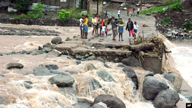 Afectados por el huracán Sandy en Jamaica, observan la fuerza de la corriente en el río Hope. Sandy dejó 21 muertos a su paso por el Caribe.
