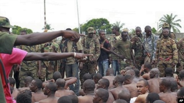 Soldiers loyal to Alassane Ouattara point to men they claim to recognize among several dozen prisoners captured during fighting and patrols in Abidjan, Ivory Coast, April 6, 2011