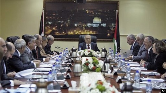 Palestinian Prime Minister Salam Fayyad speaks to his cabinet members after a meeting in the West Bank city of Ramallah, February 14, 2011