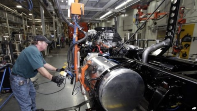 Thomas Warren installs a fuel cell on a Freightliner truck at a plant where the laid off workers will be called back to work to meet increasing demand, Cleveland, N.C., January 12, 2012.