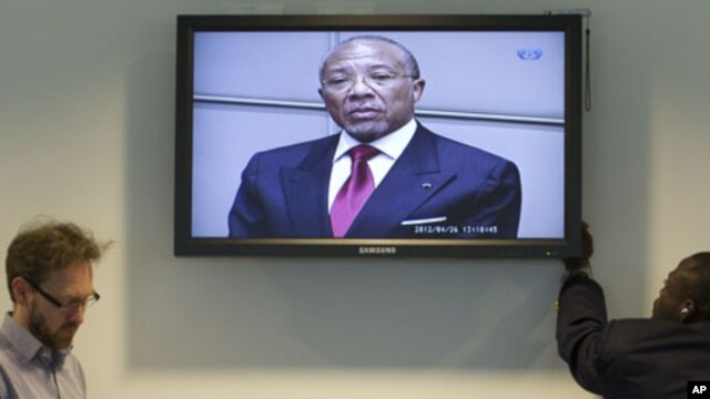 Journalists take notes as they listen to the verdict of the trial against former Liberian President Charles Taylor, seen on the screen in the court room of the Special Court for Sierra Leone in Leidschendam, near The Hague, Netherlands, April 26, 2012.