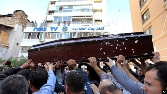 Mourners carry the coffin of Lebanese television cameraman Ali Shaaban, of Al-Jadeed TV who was shot dead on the Lebanon-Syria border, in front of Al-Jadeed TV, in Beirut, Lebanon,  April 10, 2012. 