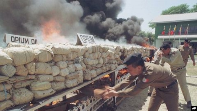 Burmese narcotic control officials put more wood to burn some six tons of seized opium, heroin and other drugs before diplomats, journalists and international business leaders in Rangoon, Burma. (File Photo)
