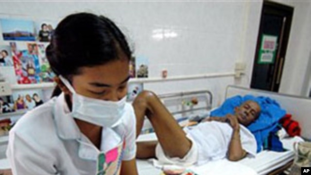 A nurse, wearing protective mask an gloves reads to a HIV/AIDS patient at the Phra Baht Nam Phu AIDS hospice near Lopburi, Thailand (File)