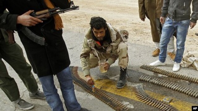 A rebel fighter cleans the ammunition rounds of an anti-aircraft weapon in Ajdabiyah, March 15, 2011