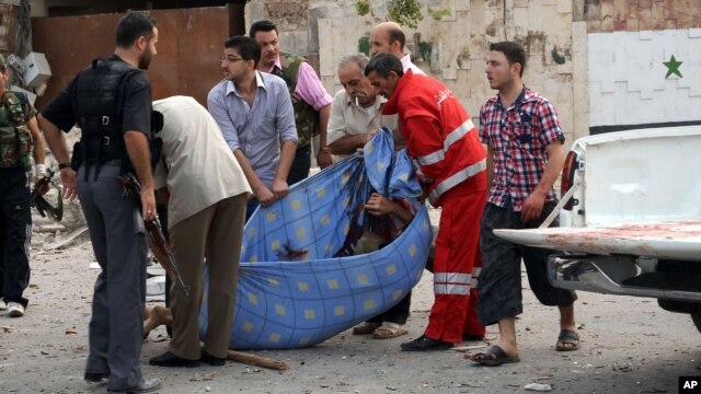 Photo released by the Syrian official news agency SANA, Syrian men carry a dead body at the scene where triple bombs exploded at the Saadallah al-Jabri square, in Aleppo, Syria, October 3, 2012.