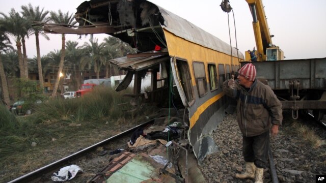 Egyptians railway workers attempt to remove debris from tracks following a train crash in Badrasheen, 40 KM south of Cairo, Egypt, January 15, 2013.