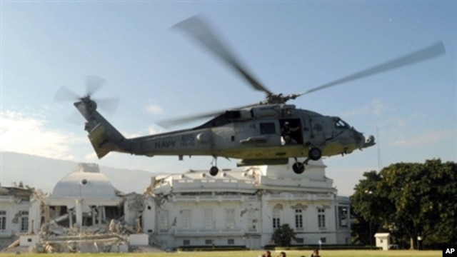 US Navy helicopter lands next to US troops in front of heavily damaged presidential palace in Port-au-Prince 19 Jan 2010