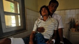 Một người đàn ông Phật giáo bị thương và cha tại một bệnh viện ở Sittwe, thủ phủ của tiểu bang Rakhine.