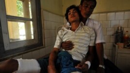 An injured Rakhine Buddhist man leans on his father at a hospital in Sittwe, the capital of Myanmar's western Rakhine state after they were recently injured at the four different districts outside Sittwe, October 26, 2012.