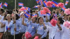 Cambodian students wave their national flags during a ceremony to celebrate the country's 59th Independence Day from France, at the Independence Monument in Phnom Penh, Cambodia, Friday, Nov. 9, 2012. (AP Photo/Heng Sinith
