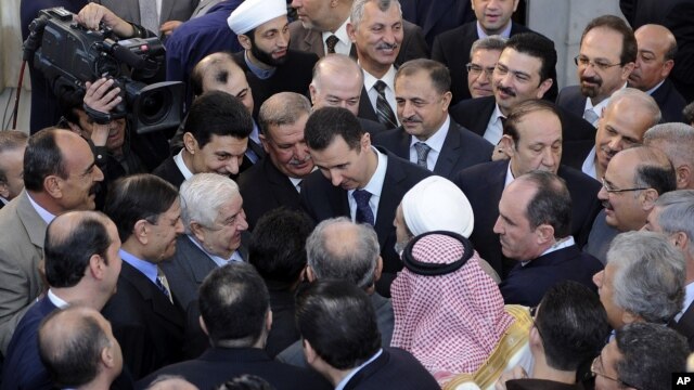 Bức ảnh Tổng thống Syria al-Assad (giữa) bắt tay những người dự lễ tại một đền thờ Hồi giáo vào ngày đầu tiên lễ Eid al-Adha, 26/10/12, do thông tấn xã SANA của Syria công bố 