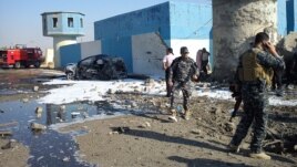 Iraqi security forces are seen at the site of a suicide bombing at a police checkpoint near Tikrit, Nov. 13, 2013.