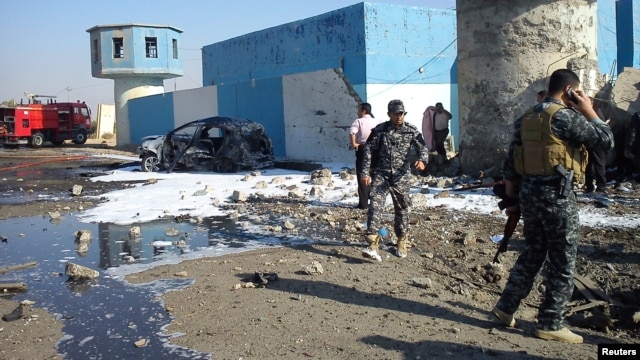 Iraqi security forces are seen at the site of a suicide bombing at a police checkpoint near Tikrit, Nov. 13, 2013.