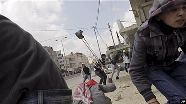 Palestinians throw stones at Israeli troops, Kalandia checkpoint between Jerusalem, Ramallah, March 30, 2012.
