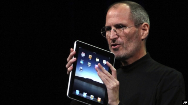 Apple Chief Executive Officer Steve Jobs holds the new 'iPad' during the launch of Apple's new tablet computing device in San Francisco, California