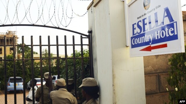 Ugandan police officers stand by the entrance of the Esella Country Hotel after police raided a gay rights workshop which was taking place in the hotel in Kampala, June 18, 2012.