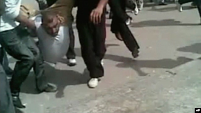 A still image taken from an amateur video purportedly taken on April 22, 2011 shows a protester being carried by a group of other protesters during a demonstration in the city of Homs, Syria