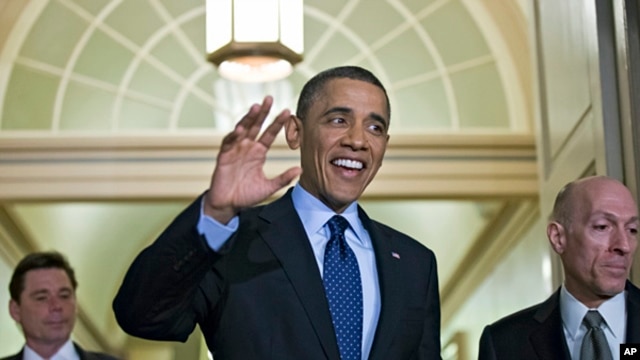 President Barack Obama, escorted by House Sergeant at Arms Paul Irving, right, waves as he arrives on Capitol Hill in Washington,  March 13, 2013.