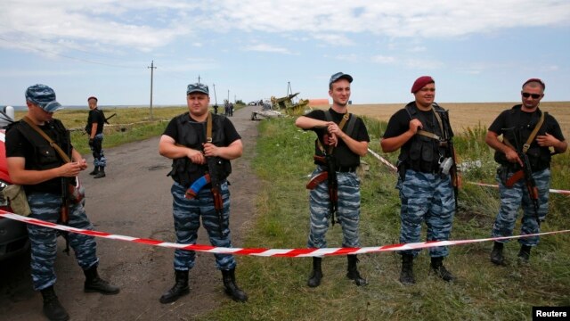 Dân quân vũ trang thân Nga đứng gác tại địa điểm nơi máy bay Malaysia bị bắn rơi gần làng Hrabove, khu vực Donetsk, ngày 20/7/2014.