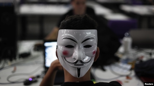 A man wearing a Guy Fawkes mask surfs the web during a "Campus Party", an annual week-long, 24-hour technology festival that gathers around 8000 hackers, developers, gamers and computer geeks from around the world in Sao Paulo, January 30, 2013.