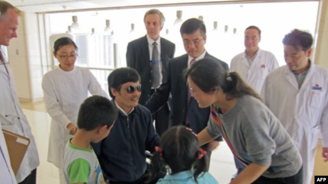 Blind activist Chen Guangcheng speaks with his wife Yuan Weijing and children as U.S. ambassador to China Gary Locke and U.S. Assistant Secretary of State for East Asian and Pacific Affairs Kurt Campbell stand nearby in a Beijing hospital this week